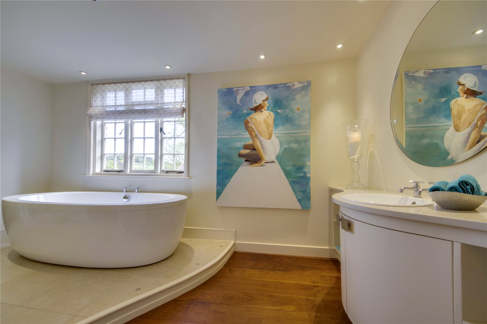 tile flooring installed under bathtub with wood flooring throughout the rest of the bathroom